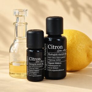 Ekologisk eterisk olja Citron i uv-skyddande glasflaskor bredvid en glaskaraff med olja, med en hel citron