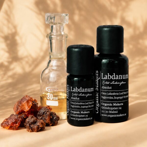 Labdanum absolut i uv-skyddande glasflaskor bredvid en glaskaraff med olja, med labdanumkåda